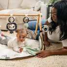 Luxe Developmental Gymini - mother by side of baby playing on gymini